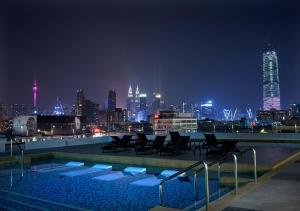 a swimming pool with a view of a city at night at KL One Residence by Nest Home [Infinity Pool & KL Skyline] in Kuala Lumpur