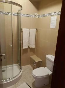 a bathroom with a toilet and a glass shower at Yria Residencial in Porto Novo