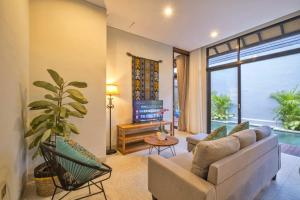 Lavina Ubud Villas في أوبود: غرفة معيشة مع أريكة وتلفزيون