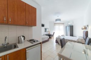a kitchen and a living room with a couch at Anelia Boutique Studios & Apartments in Faliraki