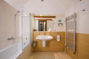 bagno con lavandino, doccia e vasca di Charles Bridge Rooms & Suites by SIVEK HOTELS a Praga