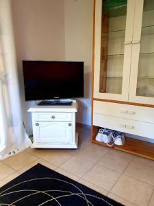 a tv sitting on a white dresser in a room at Apartment Souterrain Bühl Vimbuch Familie Bork in Bühl
