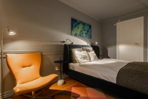 ein Schlafzimmer mit einem Bett und einem orangenen Stuhl in der Unterkunft Hotel Poseidon in Göteborg