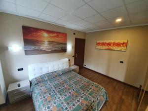 um quarto com uma cama e um quadro na parede em azalea apartments domo2 em Baveno