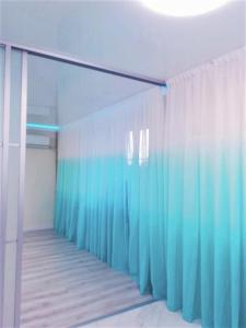 Habitación con baño con cortinas azules de ducha. en Апартаменти на центральному Кельнському бульварі, en Dnipro