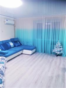 a living room with a blue couch and a christmas tree at Апартаменти в центрі завжди зі світлом in Dnipro