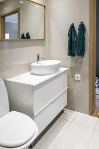 a white bathroom with a sink and a toilet at Cozy apartment in Alesund city in Ålesund