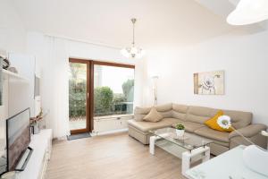 uma sala de estar branca com um sofá e uma mesa em Tanneck Wohnung 7 em Grömitz