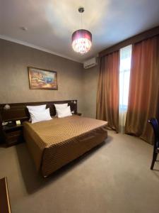 1 dormitorio con cama y lámpara de araña en Прага en Krasnodar