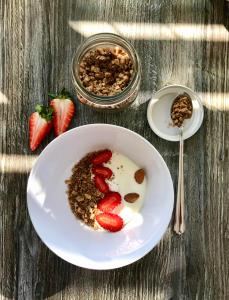 eine Schüssel Müsli mit Erdbeeren und Nüssen auf dem Tisch in der Unterkunft Hotel Quellenhof in Naturns