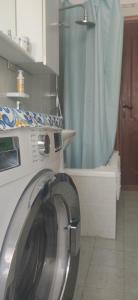 a washing machine in a bathroom with a shower at Attico in centro con vista mare e monti! in Marina