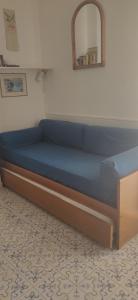 a blue bed in a room with a mirror at Attico in centro con vista mare e monti! in Marina