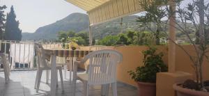 a patio with a table and chairs on a balcony at Attico in centro con vista mare e monti! in Marina
