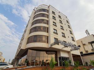 a tall white building with a sign on it at Friesian Hotel Suites in Jeddah