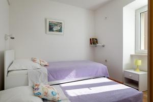 two beds in a small room with a window at Holiday Home Anima Maris in Ston