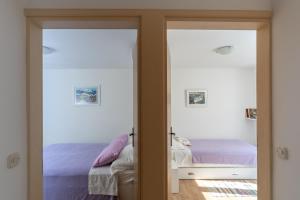a bedroom with two doors leading to a bed at Holiday Home Anima Maris in Ston