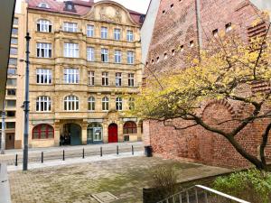 a large brick building with a tree in front of it at Old Town Romantic Apartment. Breslau-Wroclaw. in Wrocław