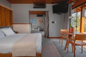 Schlafzimmer mit einem Bett, einem Schreibtisch und einem Tisch in der Unterkunft Ponta dos Ganchos Exclusive Resort in Governador Celso Ramos