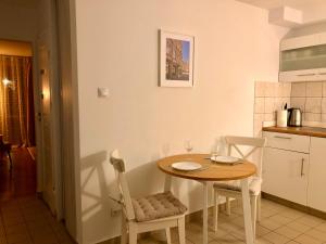 Old Town Romantic Apartment. Breslau-Wroclaw. في فروتسواف: مطبخ صغير مع طاولة وكراسي في الغرفة