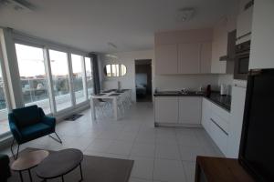 a kitchen with white cabinets and a table and chairs at White Princess in Koksijde