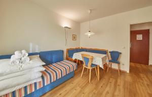 sypialnia z niebieską kanapą, stołem i krzesłami w obiekcie Appartement Delight w Saalbach Hinterglemm