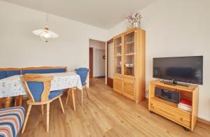 a living room with a dining table and a television at Appartement Delight in Saalbach Hinterglemm