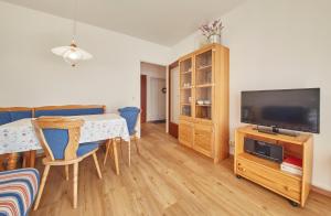 salon ze stołem i telewizorem w obiekcie Appartement Delight w Saalbach Hinterglemm