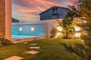 a backyard with a swimming pool and a house at Villa Elena Deluxe mit Whirlpool und POOL am MEER in Fažana