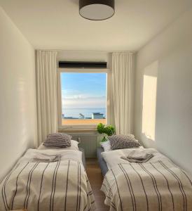 2 camas en una habitación con ventana en Ferienwohnung - Schöne Aussicht, en Immenstaad am Bodensee