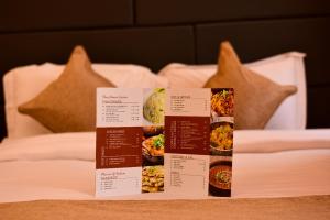a table with four different food dishes on a bed at The Grand Mafi Hotel & Spa in Sylhet