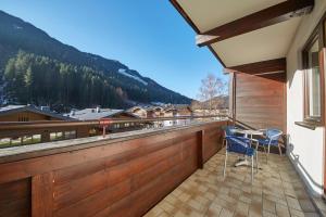 balkon z dwoma krzesłami i stołem w obiekcie Appartement Delight w Saalbach Hinterglemm