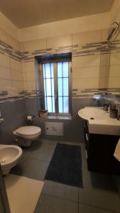 a bathroom with two sinks and a toilet and a window at Relax Home in Bari