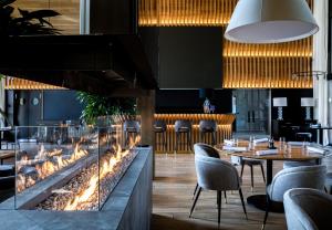 a restaurant with a large fireplace and a table and chairs at Park Hotel Dobrograd in Velikovo