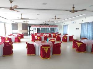 a banquet hall with red and white tables and chairs at GRAND Meridian in Pyāpali