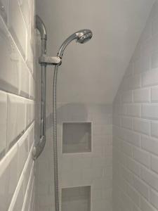 a shower with a hose in a bathroom at The Bolt Hole Hythe panoramic coast and sea views in Kent