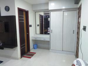 a bathroom with a large mirror and a door with a tv at GRAND Meridian in Pyāpali