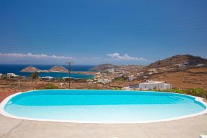 a large blue swimming pool with a view of the ocean at VENUS VIEW in Kalafatis