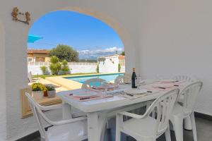 a white table and chairs on a patio with a pool at Montrose in Jávea