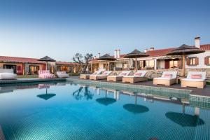 a pool at a resort with lounge chairs at Monte do Cardal in Odeceixe