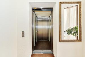 a hallway with a mirror and a elevator at Palantin Hotel in Saint Petersburg