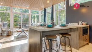 a kitchen with a island with two bar stools at The Marco-Polo of Portneuf - Open on nature - Private SPA Pool Sauna in Pont-Rouge