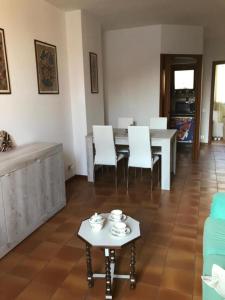 Casa Chia Lago Maggiore في لافينو: غرفة معيشة مع طاولة وكراسي بيضاء