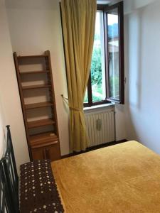 1 dormitorio con cama y ventana en Casa Chia Lago Maggiore, en Laveno