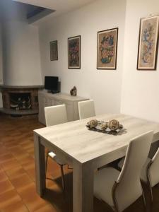 a dining room with a table and white chairs at Casa Chia Lago Maggiore in Laveno-Mombello