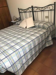 1 cama con manta de cuadros blanca y negra en Casa Chia Lago Maggiore, en Laveno