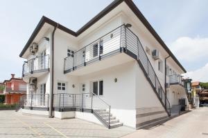 a white building with a balcony on the side at Hotel & Residence Progresso in Lido di Jesolo