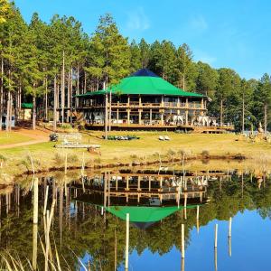 a large building with a green roof reflected in the water at Tedesco Eco Park in São Francisco de Paula