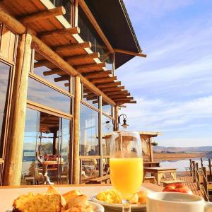 a glass of orange juice sitting on a table with food at Tedesco Eco Park in São Francisco de Paula