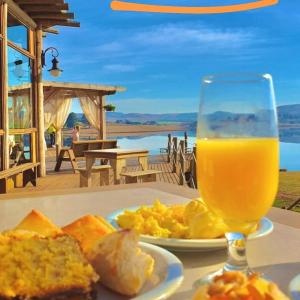 a plate of food and a glass of orange juice at Tedesco Eco Park in São Francisco de Paula