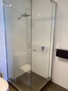 a glass shower in a bathroom with a toilet at BEAUTIFUL CITY VIEWS CLOSE CITY AIRPORT FREE WINE in Perth